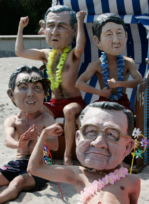 Activists of British charity organization Oxfam, wearing masks of G8 heads of state, pose on the beach in Kuehlungsborn June 7, 2007. Leaders from the world's major industrialised nations meet in the Baltic resort of Heiligendamm on June 6-8 for a Group of Eight (G8) summit.